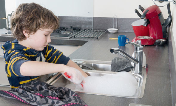 Boy doing the dishes in a modern kitchen